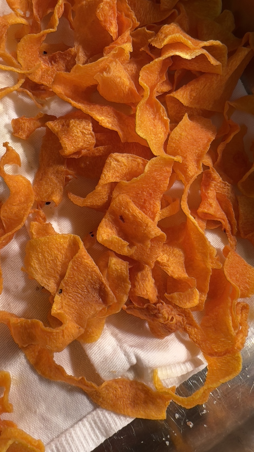 Thin golden butternut squash crisps draining on kitchen paper